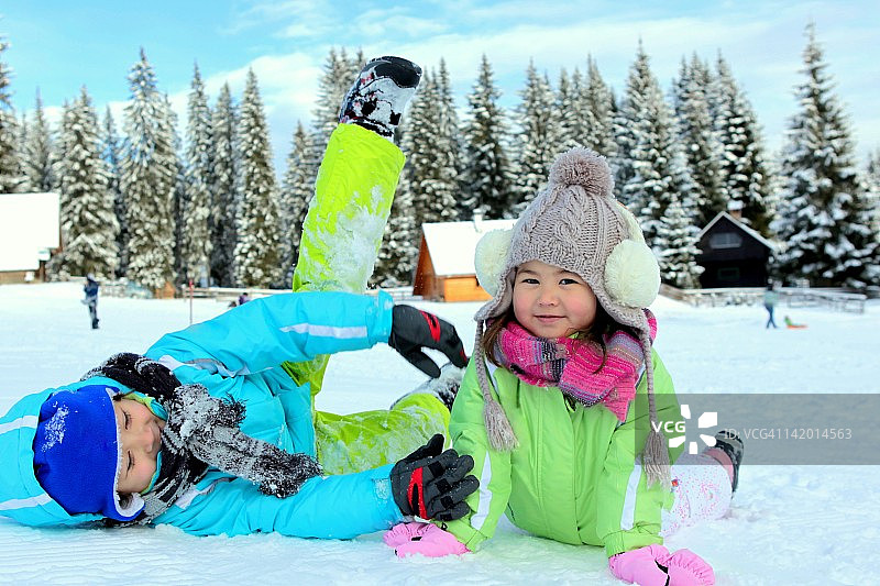 男孩和女孩躺在雪地上图片素材
