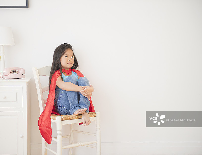 穿着披风的韩国女孩坐在椅子上图片素材