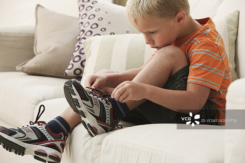 系鞋带的白人男孩图片素材