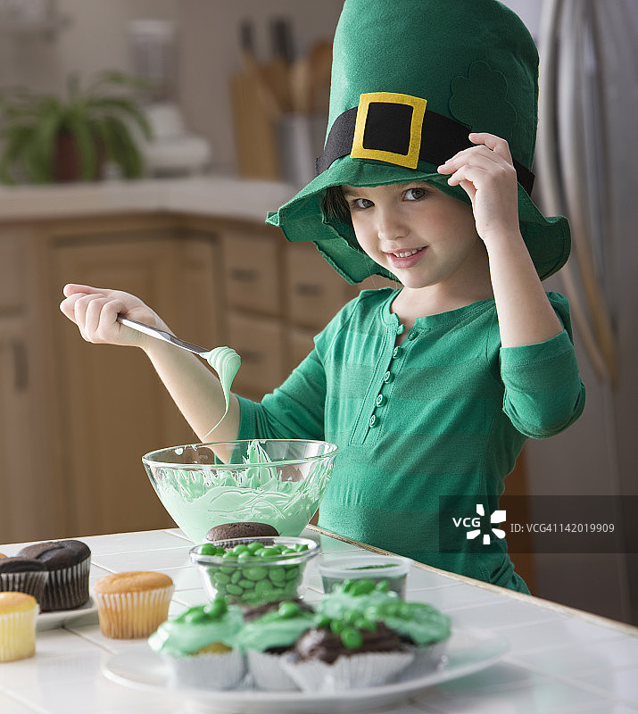 制作圣帕特里克节纸杯蛋糕的白人女孩图片素材