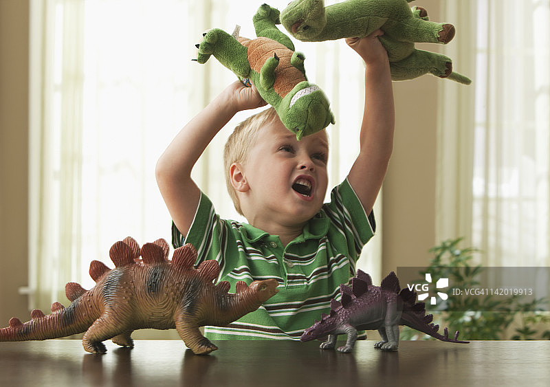 白人男孩玩恐龙玩具图片素材