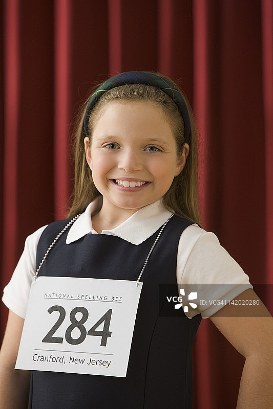 白人女孩站在舞台上，戴着比赛号码图片素材