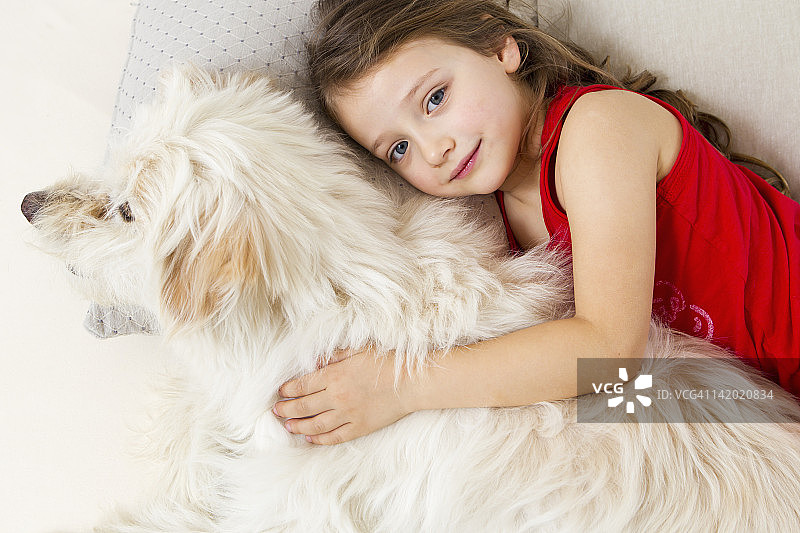 女孩和狗在床上放松图片素材
