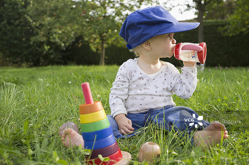 宝宝在草地上喝果汁图片素材