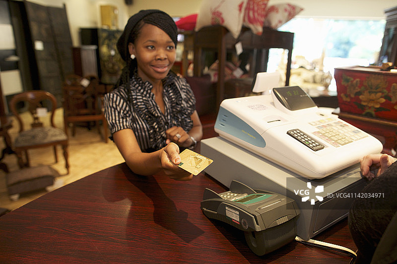 年轻女人在南非夸祖鲁-纳塔尔省彼得马里茨堡用信用卡支付图片素材