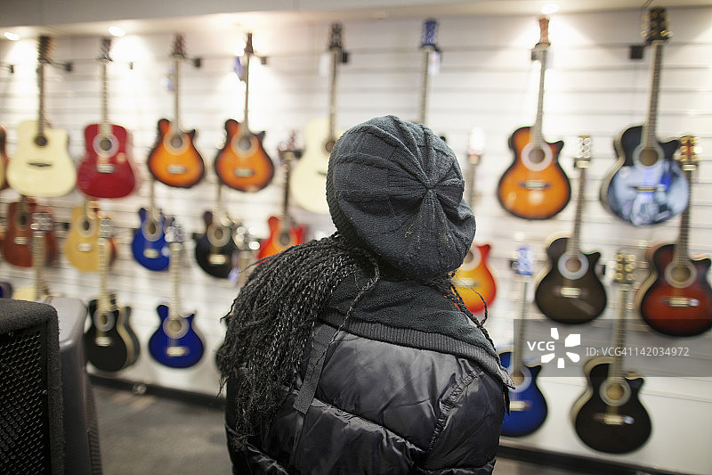 在南非夸祖鲁-纳塔尔省彼得马里茨堡看着吉他墙的年轻女人图片素材