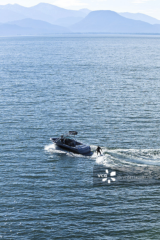 快乐的运动型女子在爱达荷州的滑水艇后进行尾波冲浪图片素材