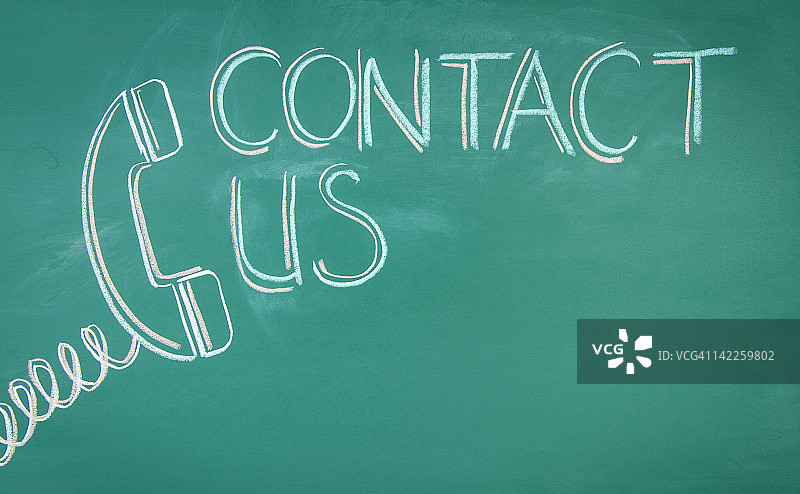 用粉笔在绿板上绘制的“联系我们”文本图片素材