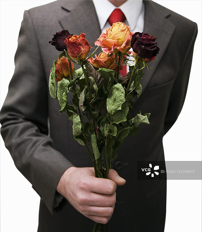 男人拿着一束枯萎的花图片素材