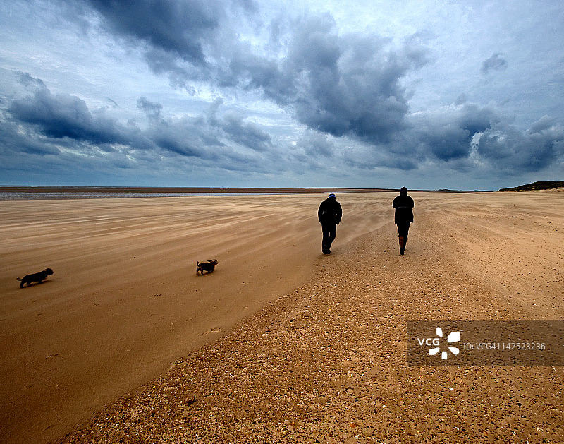 在沙滩上行走的男人们图片素材