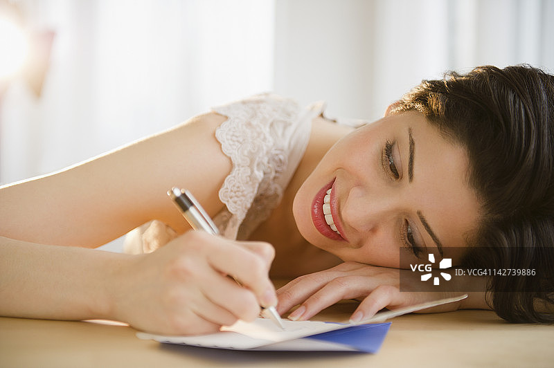 混血女人在生日贺卡上写字图片素材