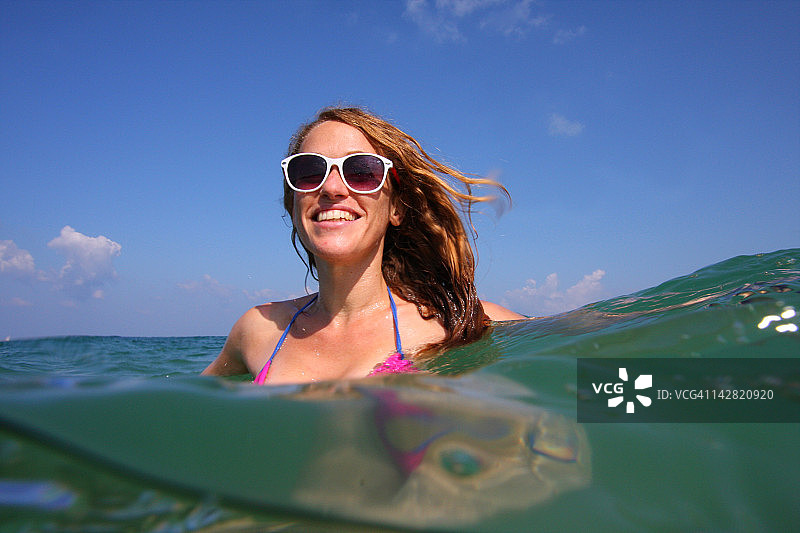 女人在水中行走，背景是天空图片素材