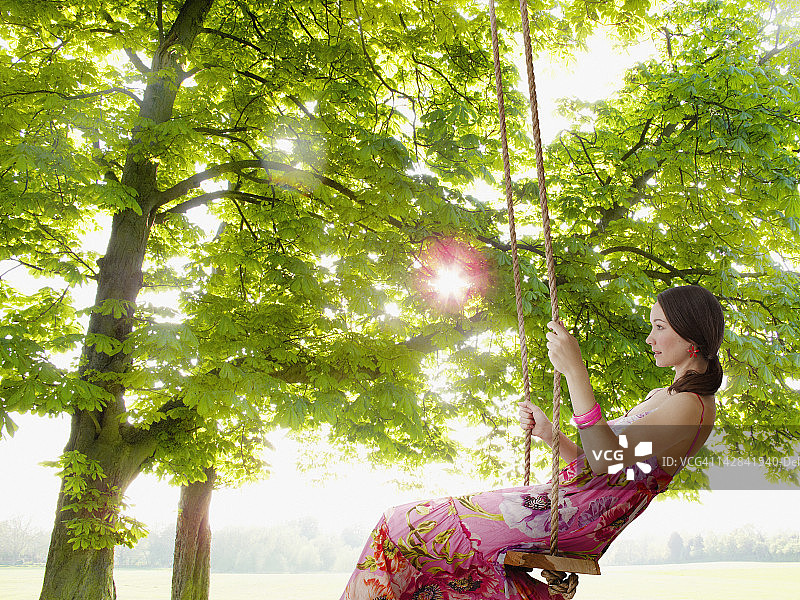 在田野里荡树枝的女人图片素材