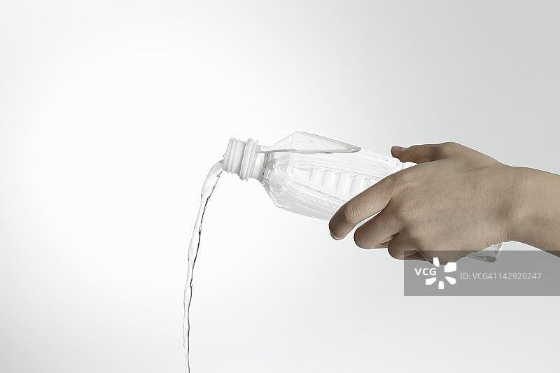 从瓶子里倒水的手图片素材