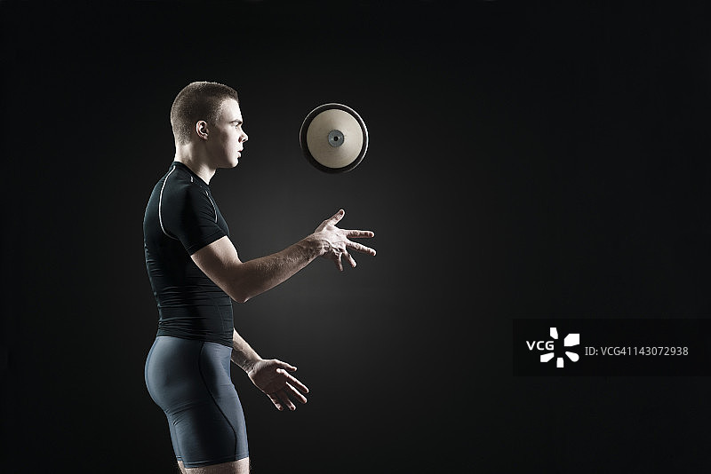 男性运动员在空中投掷铁饼图片素材