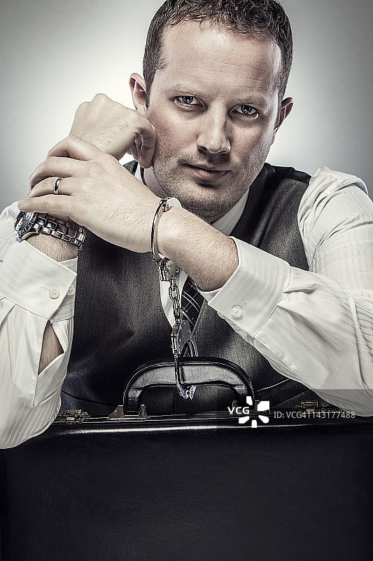 CEO被手铐铐在公文包上图片素材