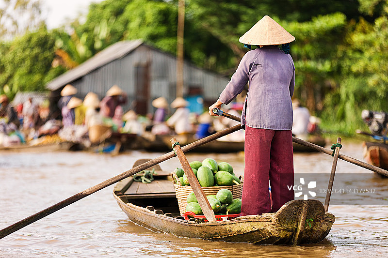 越南女人在湄公河三角洲划船图片素材