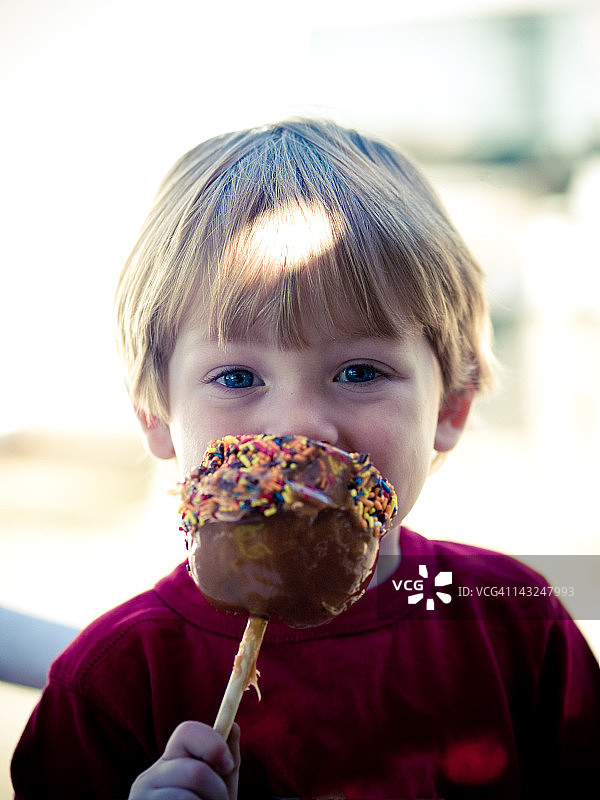 男孩吃焦糖苹果图片素材