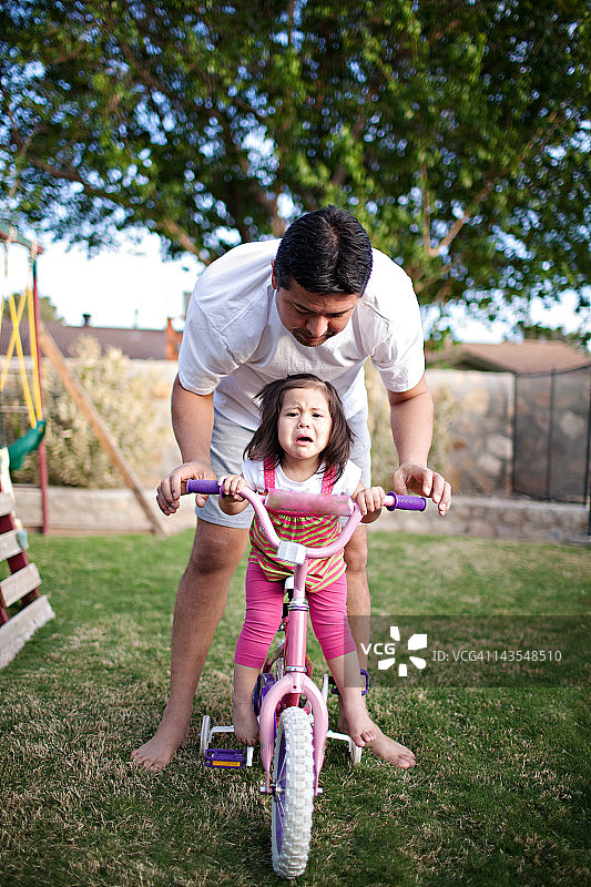 幼儿在自行车上哭泣图片素材