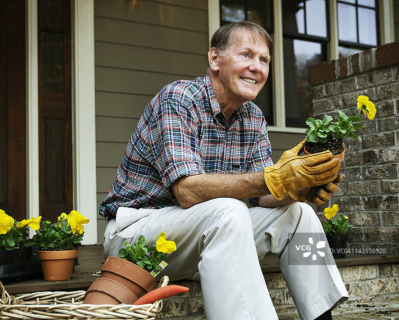 拿着花盆的年长园丁图片素材