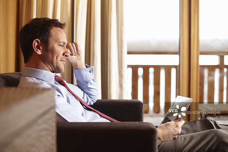 在酒店房间使用平板电脑的女商人图片素材