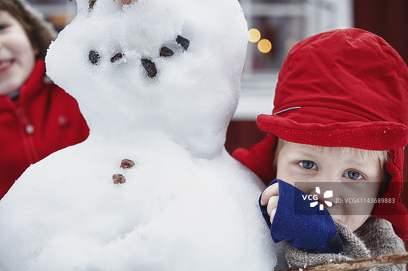 男孩拥抱雪人的特写镜头图片素材