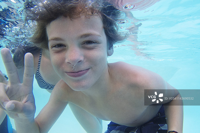 在泳池里玩耍的微笑男孩图片素材
