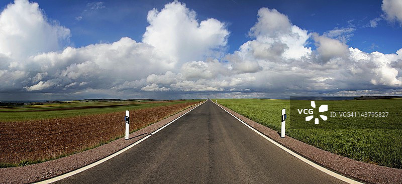 孤独的柏油路和多云的天空图片素材