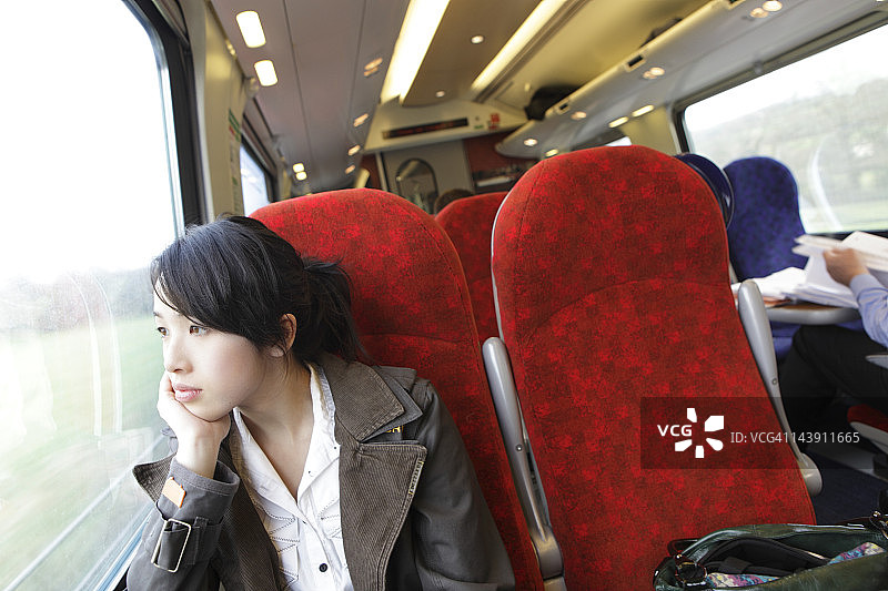 坐在火车上向窗外看的女孩图片素材