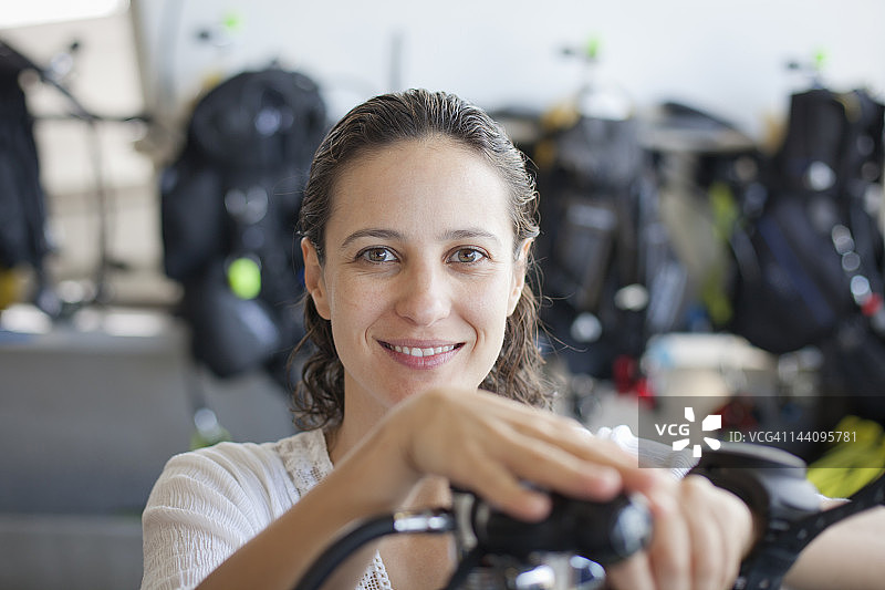 一名水肺潜水员在船甲板上检查设备图片素材