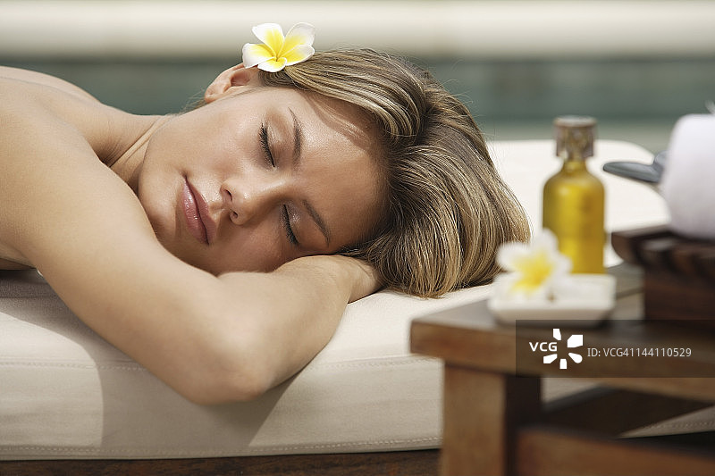 女人躺在室外的按摩台上图片素材