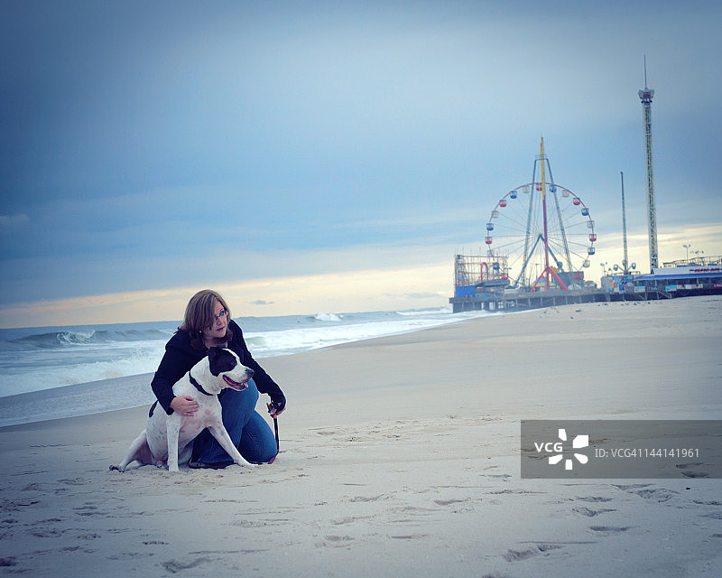 海边高地上的狗和女人图片素材