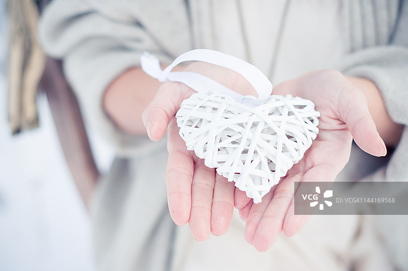 手持白色丝带心图片素材