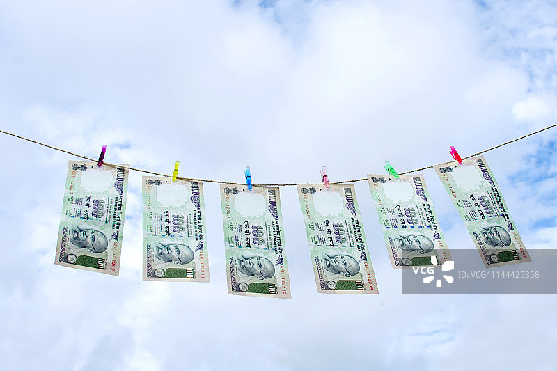挂在晾衣绳上的一百卢比纸币，低角度视图图片素材