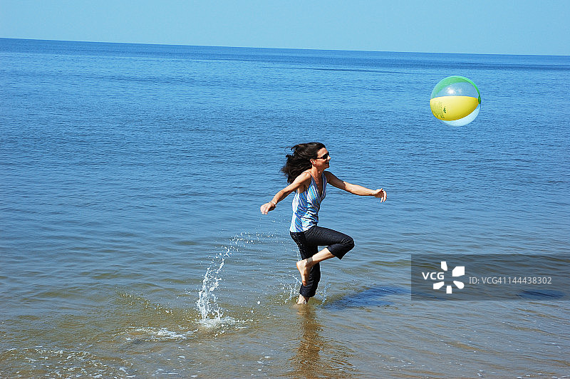 年轻女人玩沙滩球图片素材