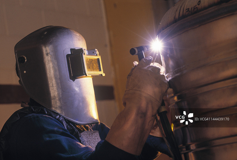 焊接工人焊接不锈钢容器图片素材
