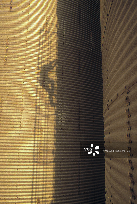 男人爬上粮仓的影子图片素材