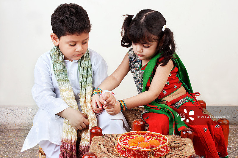 姐姐给弟弟系 रक्षा बंधन 手绳图片素材