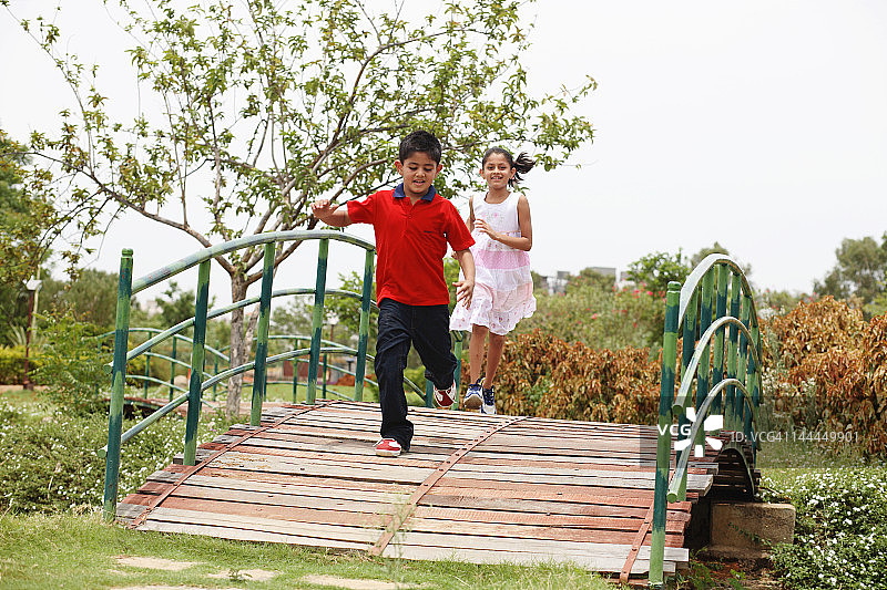 两个孩子在人行桥上玩耍图片素材
