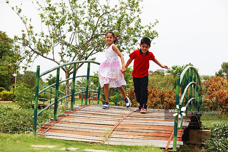 两个孩子在人行桥上玩耍图片素材