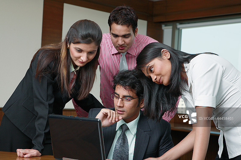 商务人士在办公室使用笔记本电脑开会图片素材