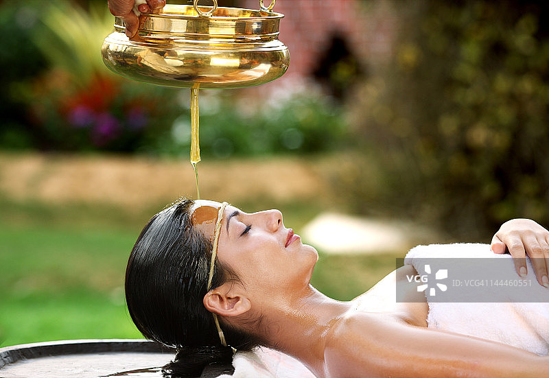 年轻女子接受额头滴油疗法图片素材