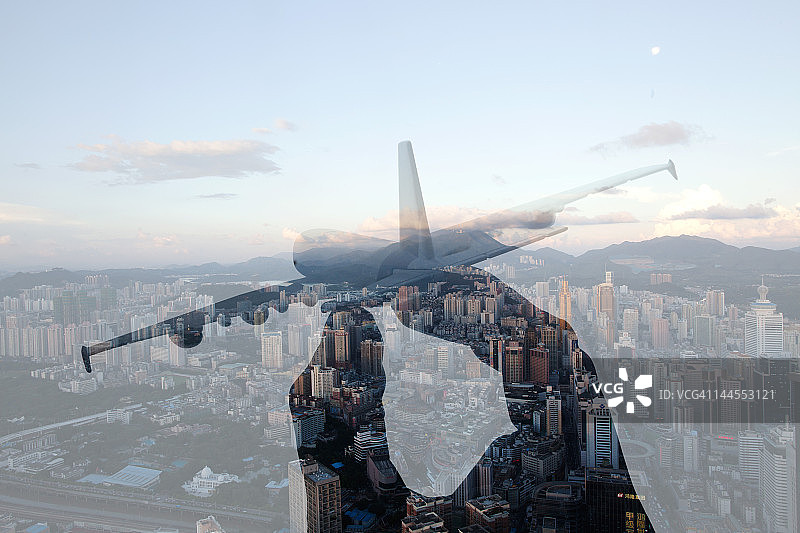 手持玩具飞机的双重曝光图片素材