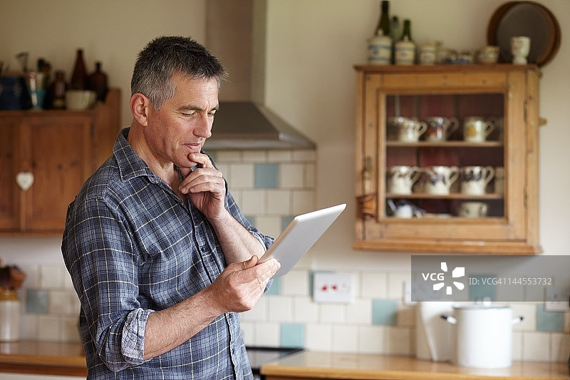 男人在厨房使用数位板电脑图片素材