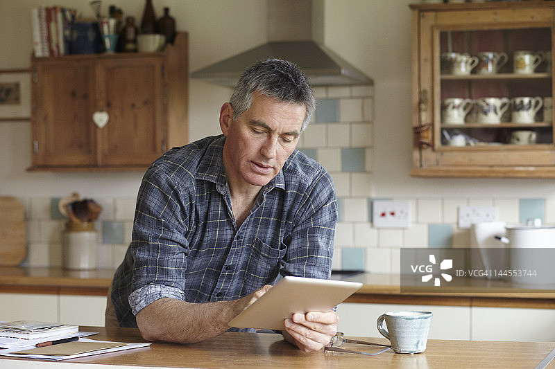 男人在厨房使用数位板电脑图片素材