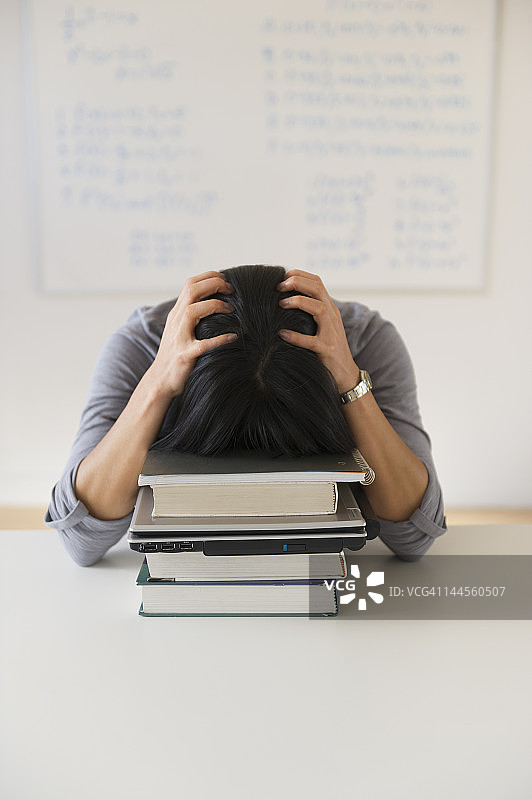 美国新泽西州泽西市：沮丧的女人在写满方程式的黑板前图片素材