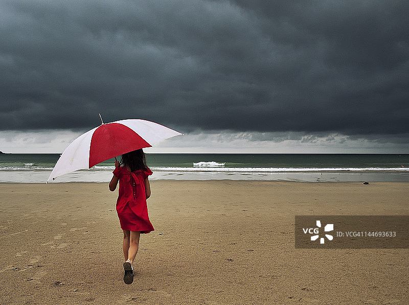 在海滩上撑伞的女孩图片素材