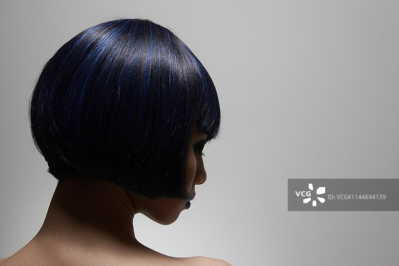 蓝色头发的年轻女人侧面照图片素材