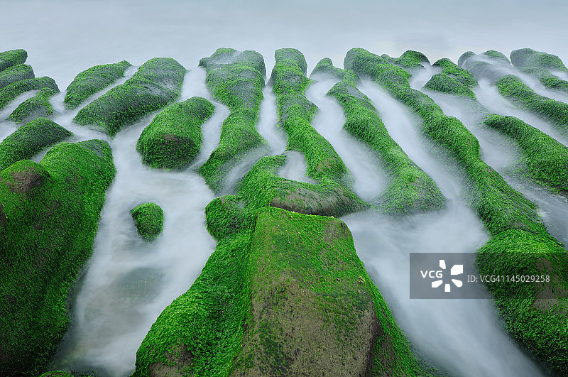 绿色岩石上雾蒙蒙的海浪图片素材