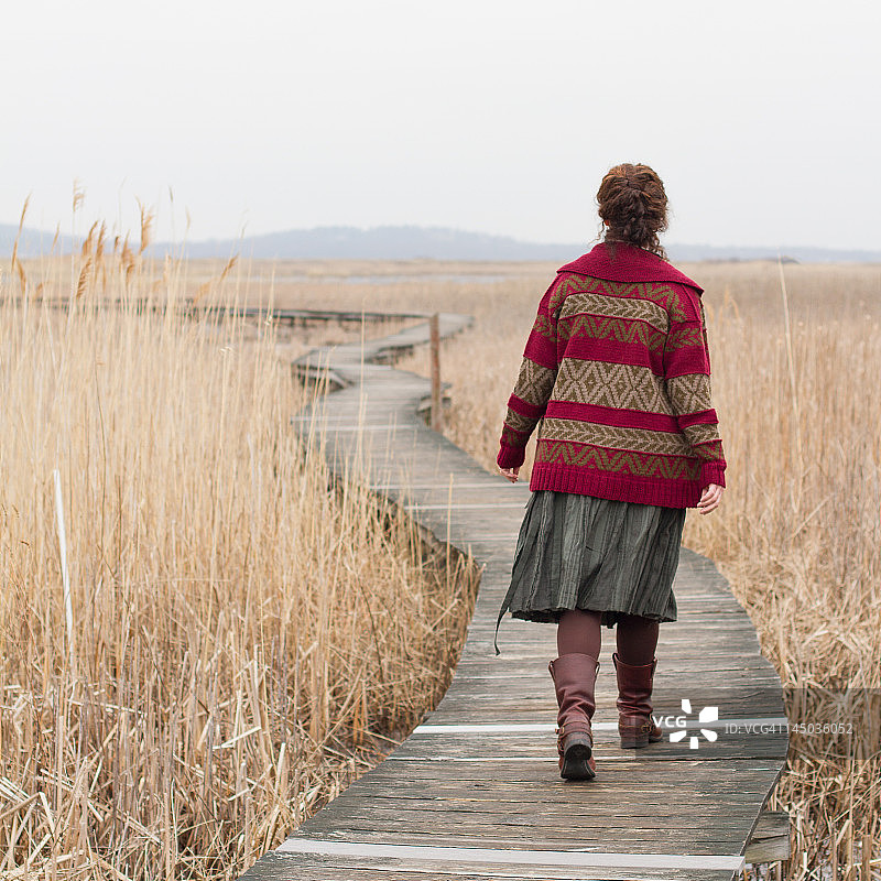 女人走在木板路上图片素材